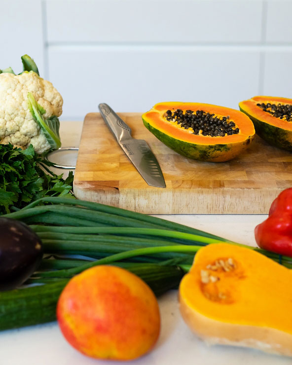 A cutting board displaying fresh vegetables alongside a knife, emphasizing healthy meal preparation by accredited practicing dietitians.