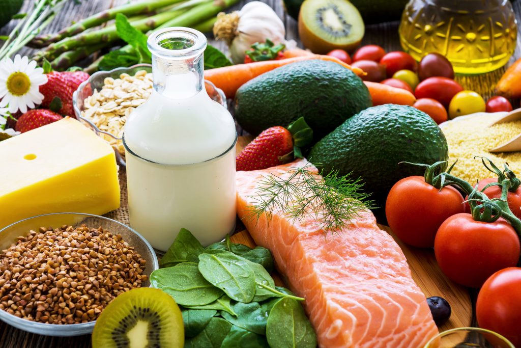 A variety of healthy foods such as fish, vegetables, milk, eggs, and cheese, beneficial for managing chronic health conditions.