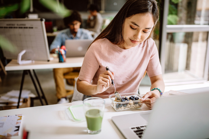 An employee having a vegetarian breakfast at work, highlighting corporate dietitian services and workplace nutrition programs